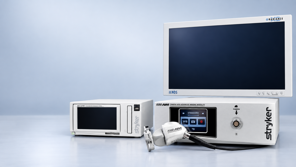 Stryker medical imaging equipment set including a control console with a large display screen, a smaller monitor, and an attached handheld probe, photographed on a clean light blue studio background.